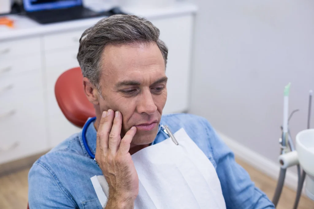 Unhappy man experiencing severe toothache in need of emergency dentistry