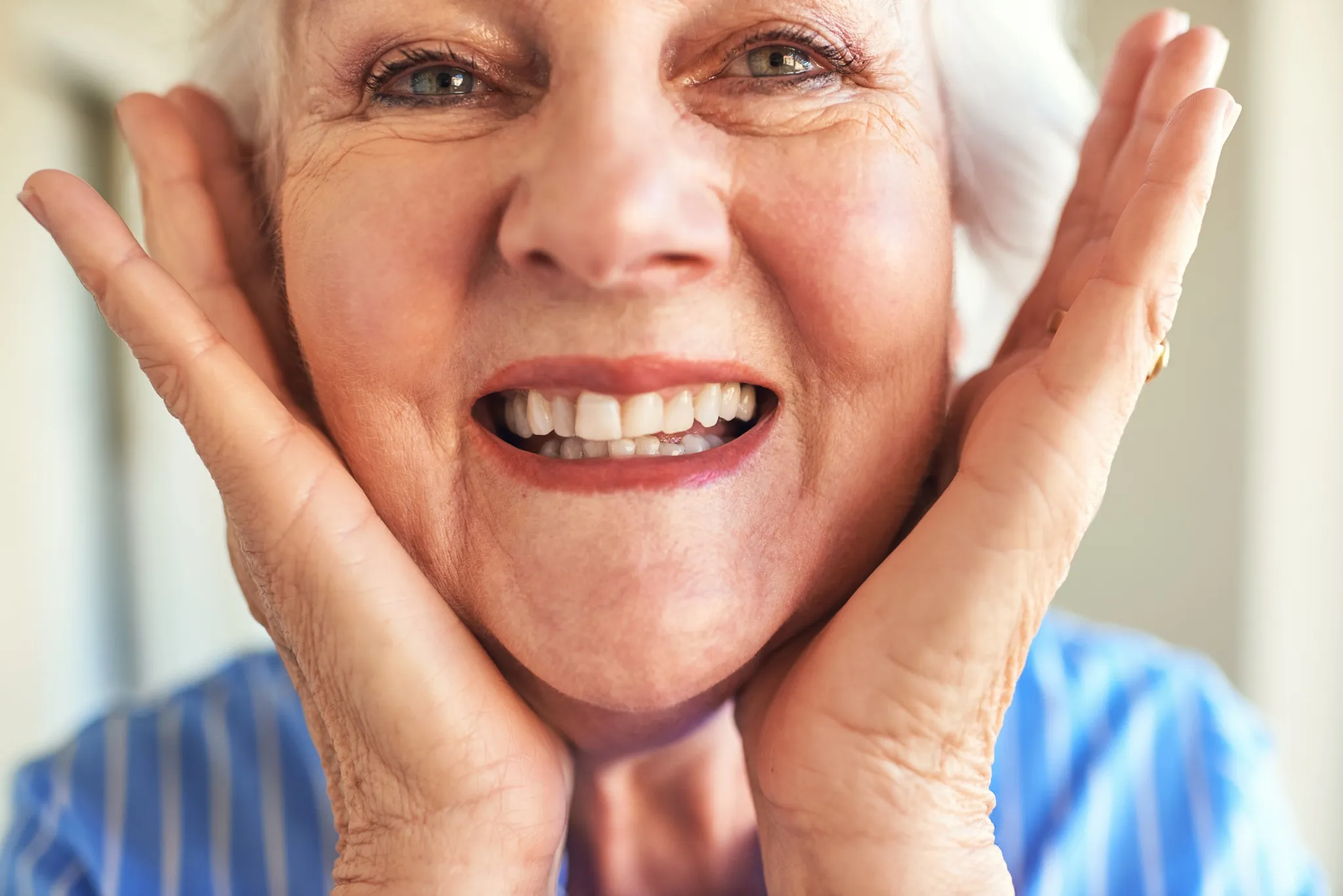 Happy senior woman smiling confidently after receiving dental implants in Oakhurst