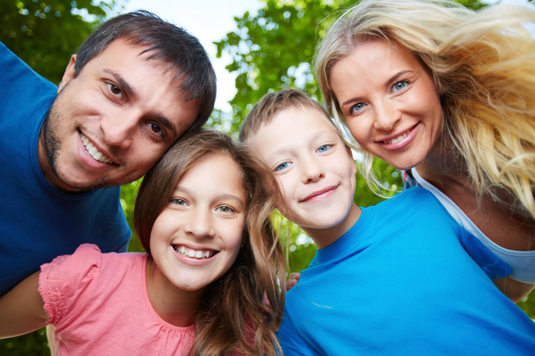 Smiling family of four enjoying time outdoors, representing happy dental patients in Fresno