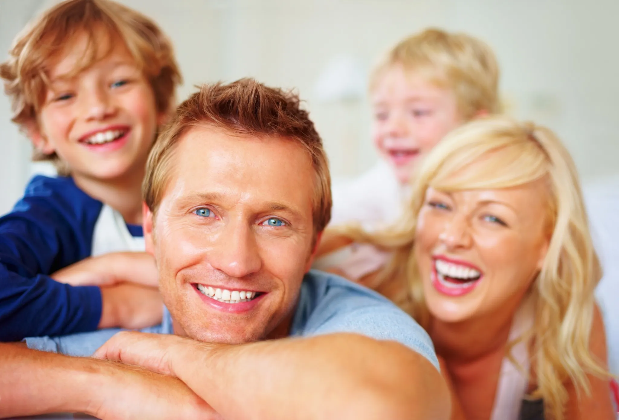Parents and kids laughing with visible healthy teeth, promoting dental wellness