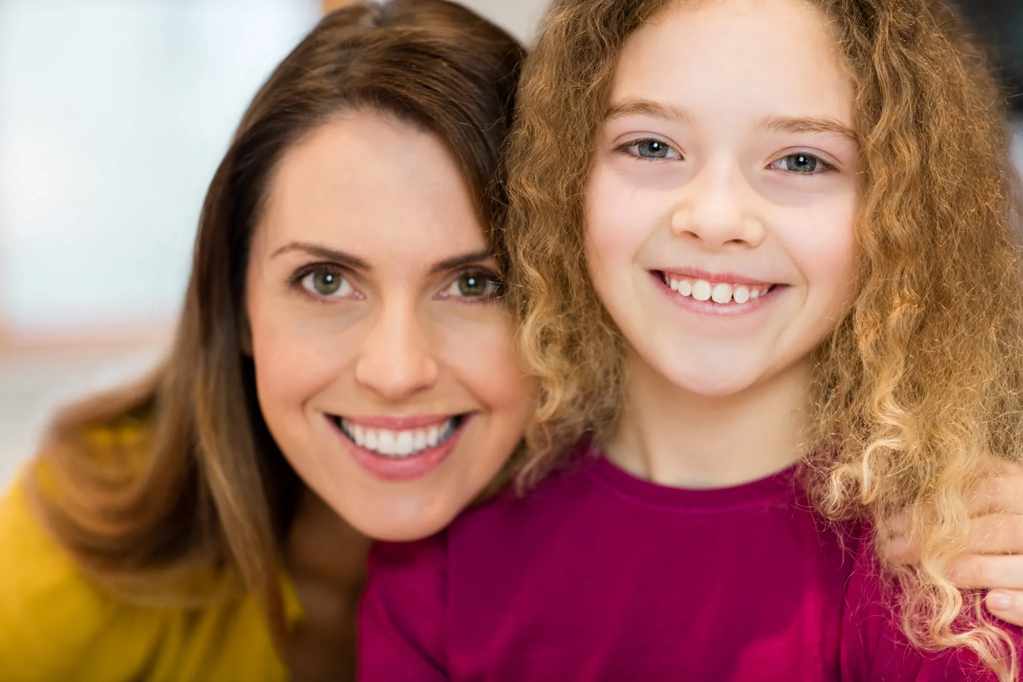 Happy mother and daughter smiling with healthy gums and teeth