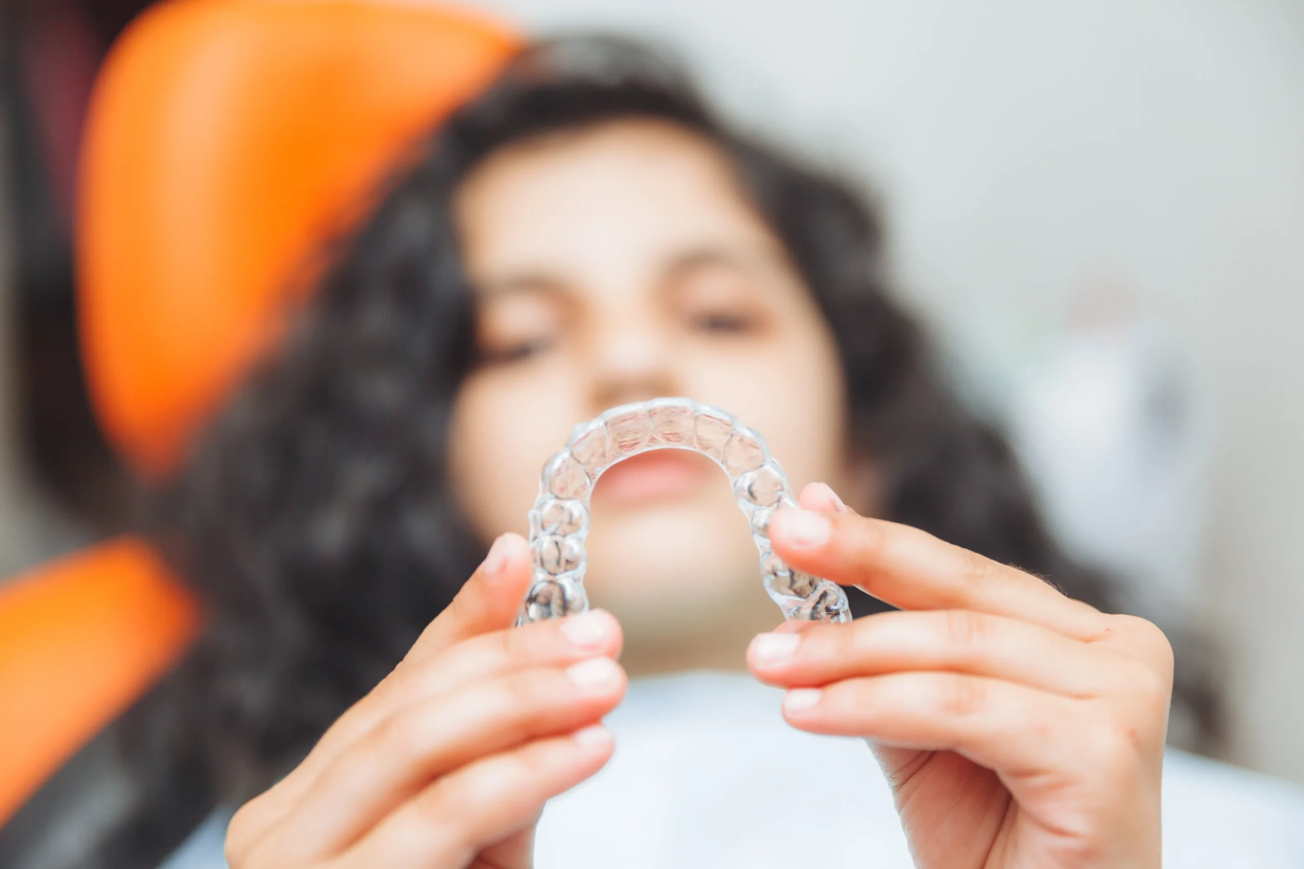teen girl holding braces dentist puts braces girl dental care orthodontic concept scaled