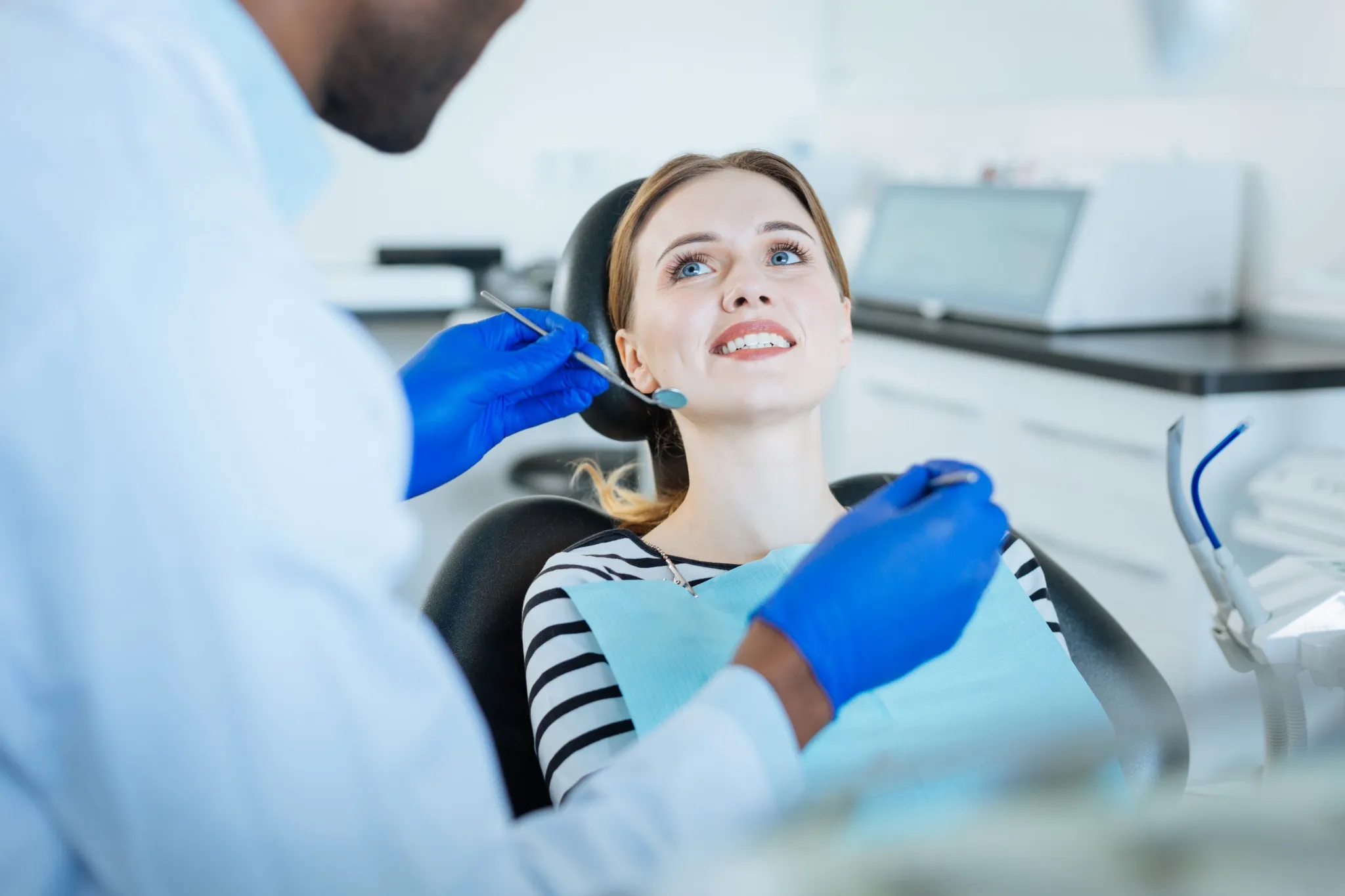 Young woman showing teeth while consulting dentist, suitable for gum treatment